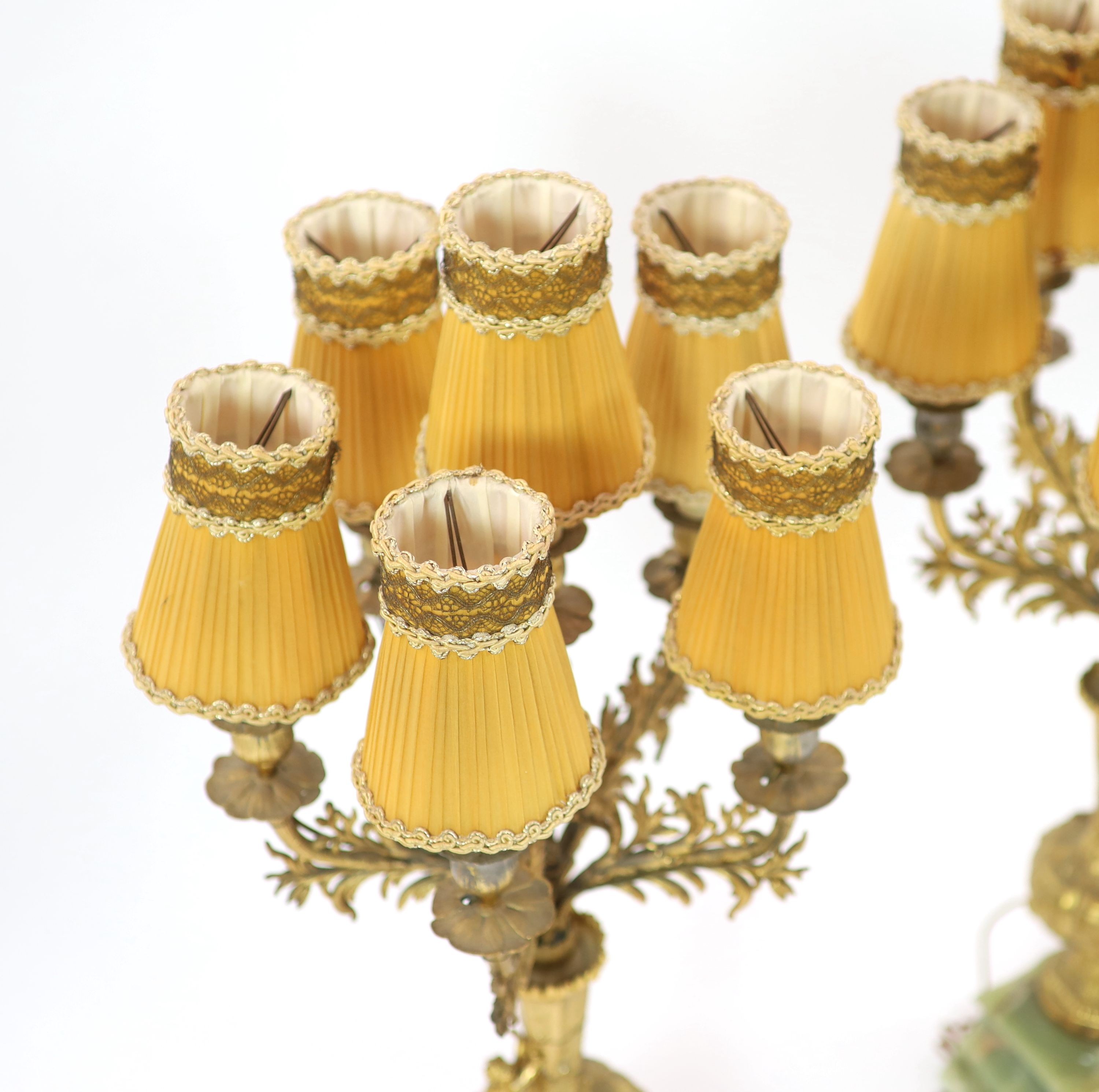 A pair of elaborate gilt metal and green onyx six-light candelabra table lamps on pedestal urn supports incorporating champlevé enamel plaques H 70cm.